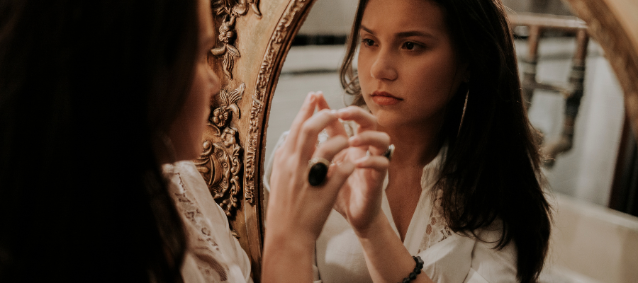 woman looking at herself in the mirror